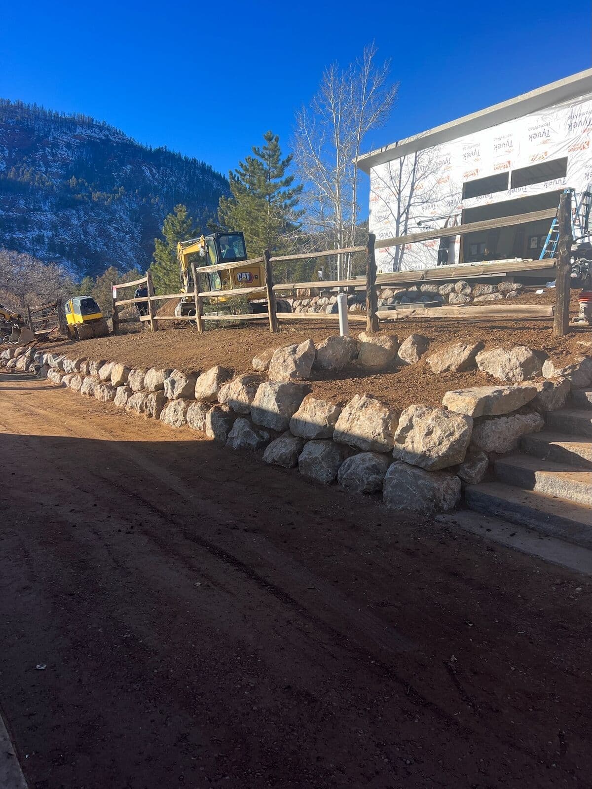 Boulder retaining wall construction at a building site in Durango, Colorado