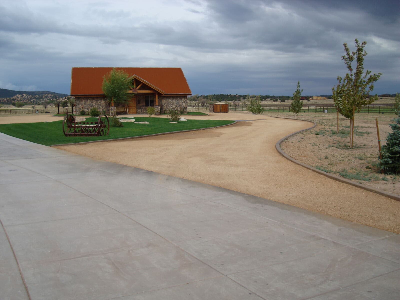 Concrete driveway entrance with road base and finished landscaping at a ranch home near Durango, Colorado