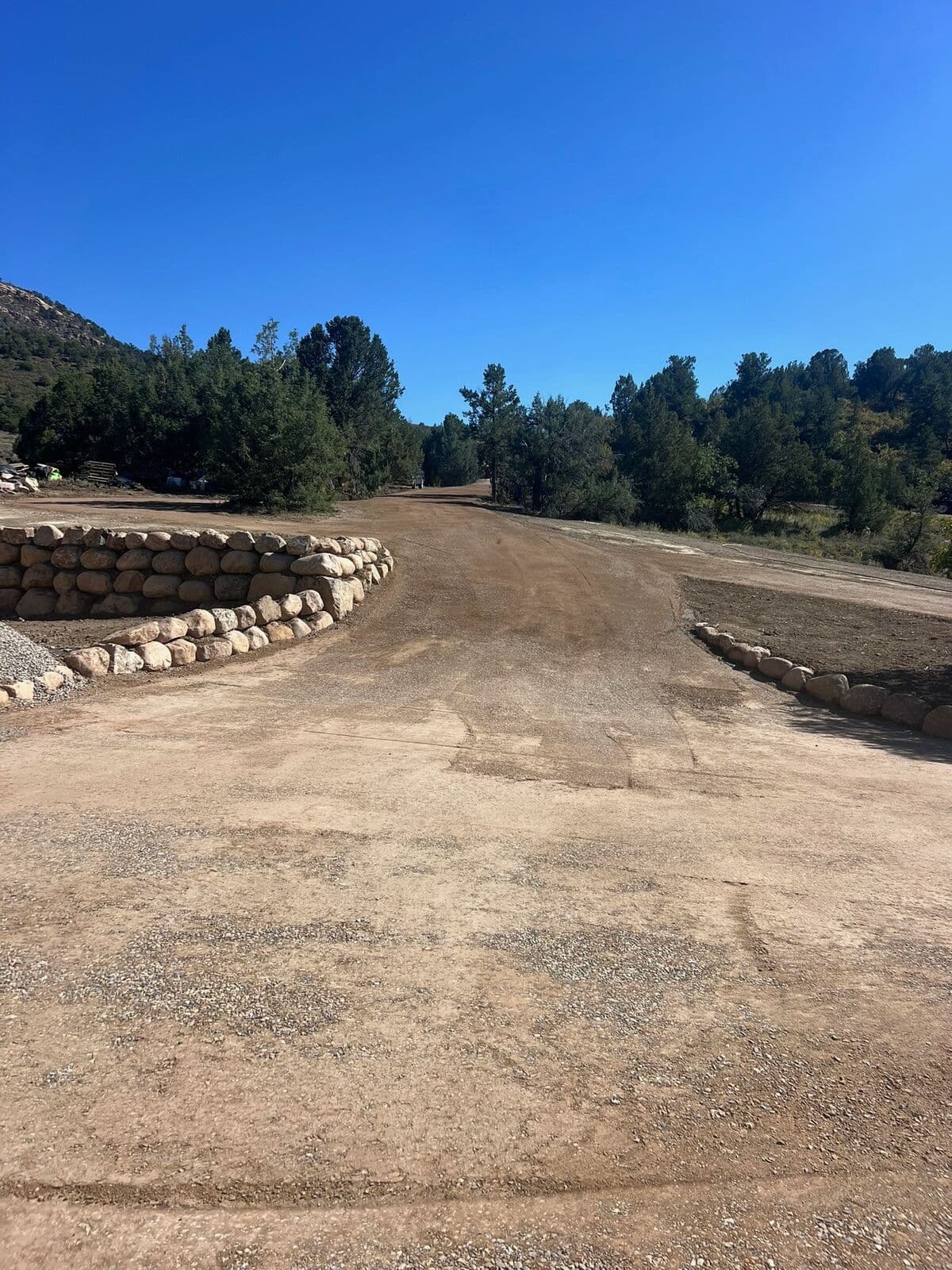 Gravel road with boulder retaining wall on a mountain property near Durango, Colorado