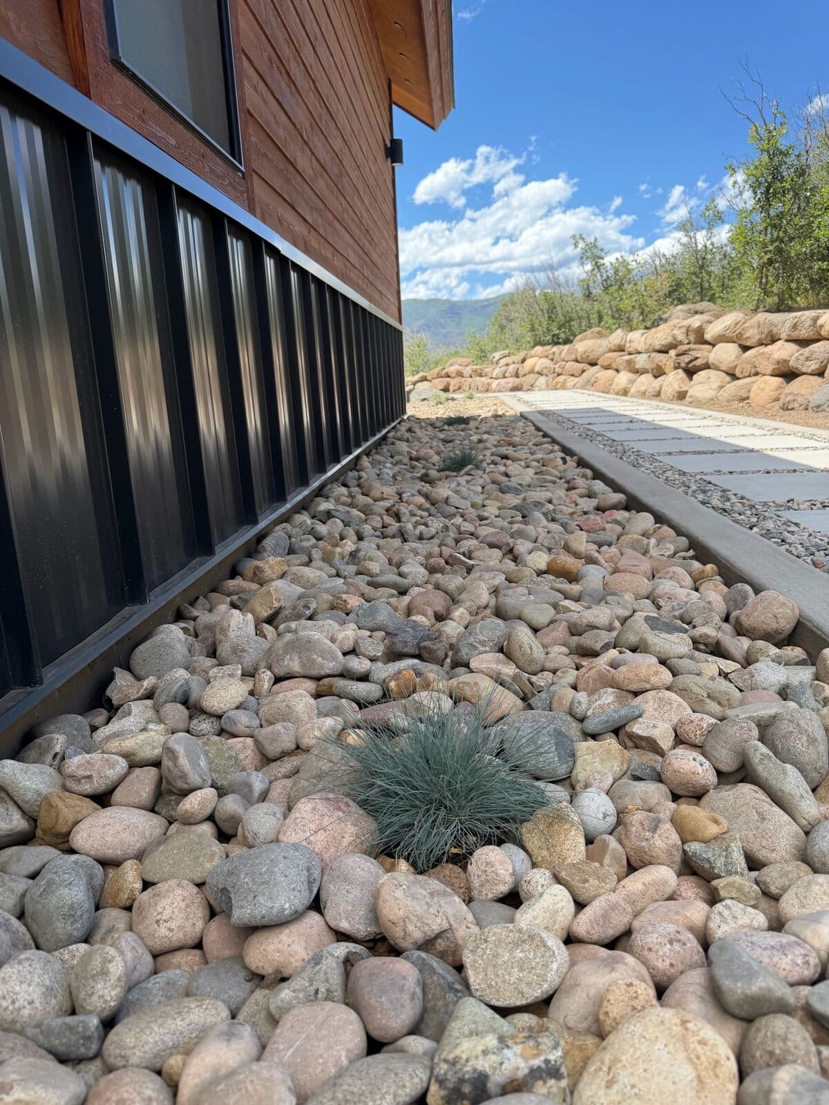 River rock drainage bed protecting a home foundation in Durango, Colorado by LandEx Earthworks
