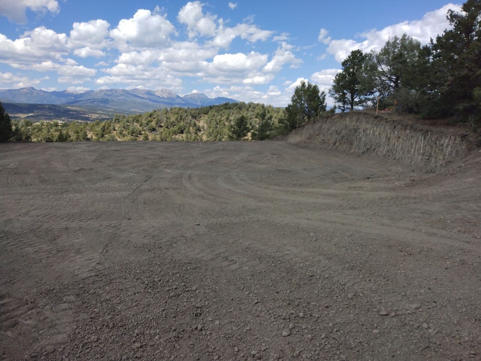 Site grading and building pad preparation with San Juan Mountain views near Durango, Colorado