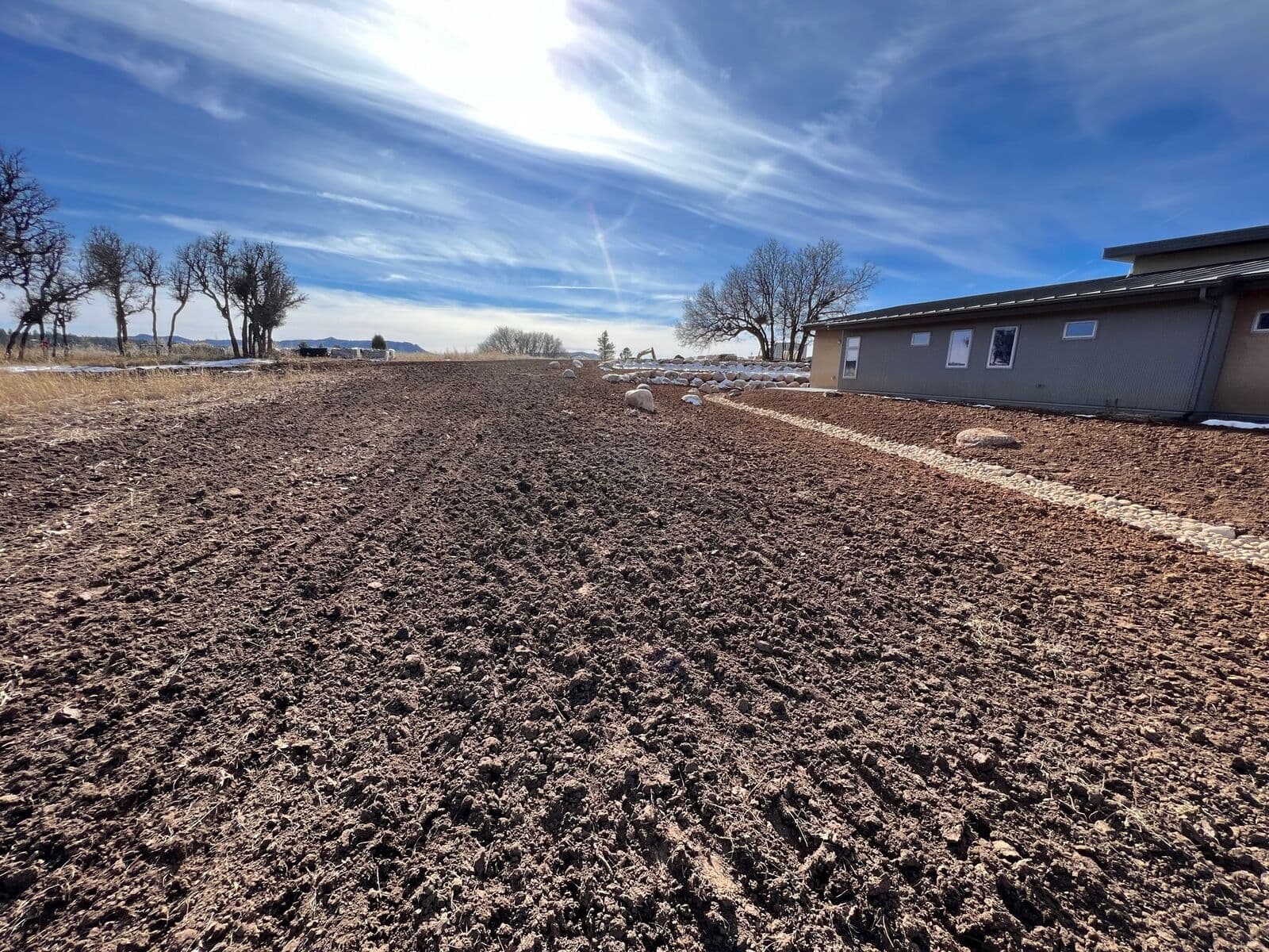 Topsoil spreading and lawn preparation beside a new home in Durango, Colorado